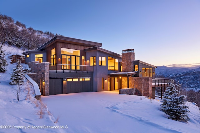 contemporary home featuring a mountain view, a garage, and a balcony