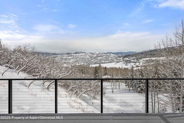 snow covered back of property with a mountain view