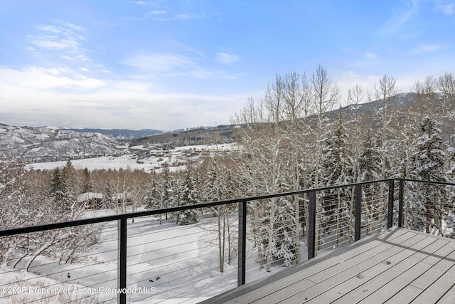 snow covered deck featuring a mountain view