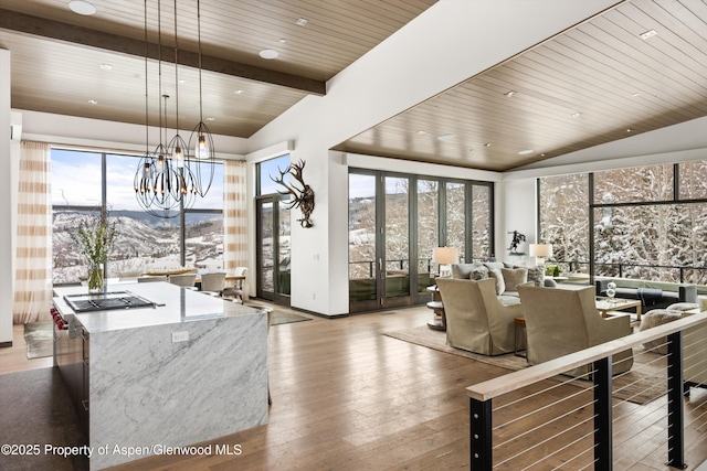 dining space with hardwood / wood-style flooring, beam ceiling, a mountain view, a chandelier, and wood ceiling