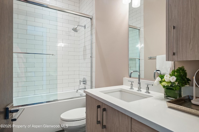 full bathroom with toilet, vanity, and combined bath / shower with glass door