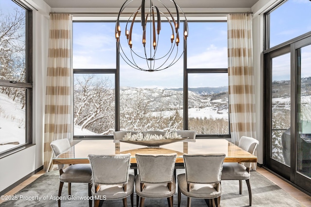 sunroom featuring a chandelier and a mountain view