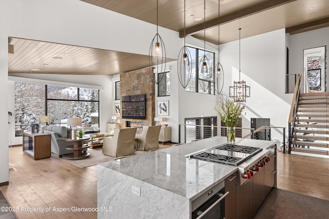 kitchen with hardwood / wood-style floors, an inviting chandelier, wooden ceiling, and appliances with stainless steel finishes