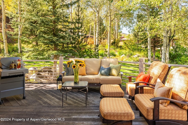 wooden terrace featuring outdoor lounge area and a grill