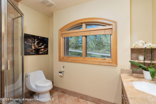 bathroom featuring a shower with shower door, toilet, vanity, and tile patterned flooring