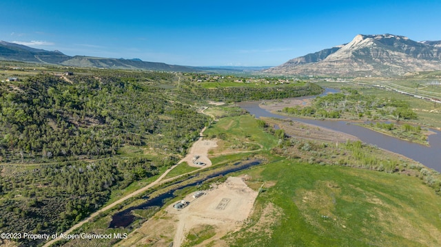 drone / aerial view featuring a water and mountain view