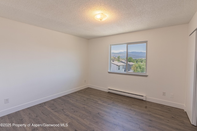 2655 Acacia Ave, Rifle, CO 81650 - spare room with baseboard heating, dark wood-style floors, and a textured ceiling