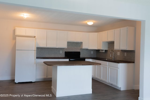 2655 Acacia Ave, Rifle, CO 81650 - kitchen with freestanding refrigerator, black electric range oven, backsplash, and white cabinetry
