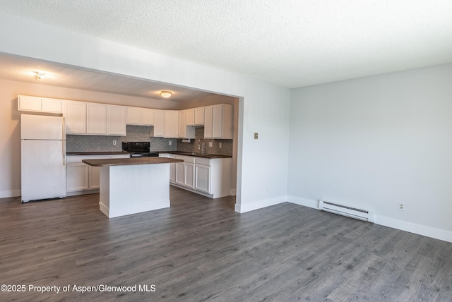 2655 Acacia Ave, Rifle, CO 81650 - kitchen featuring freestanding refrigerator, a baseboard radiator, black range with electric cooktop, dark countertops, and a kitchen island