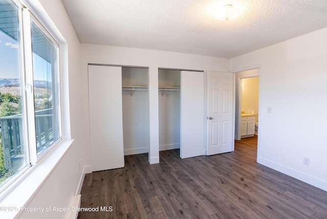 2655 Acacia Ave, Rifle, CO 81650 - unfurnished bedroom featuring multiple closets, dark wood-type flooring, and a textured ceiling
