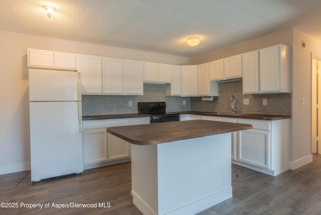 2655 Acacia Ave, Rifle, CO 81650 - kitchen with freestanding refrigerator, black range with electric stovetop, butcher block counters, white cabinets, and decorative backsplash