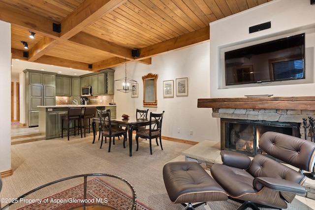 610 S W End St Unit D203, Aspen, CO 81611 - living area featuring wood ceiling with exposed beams, light colored carpet, baseboards, and a fireplace