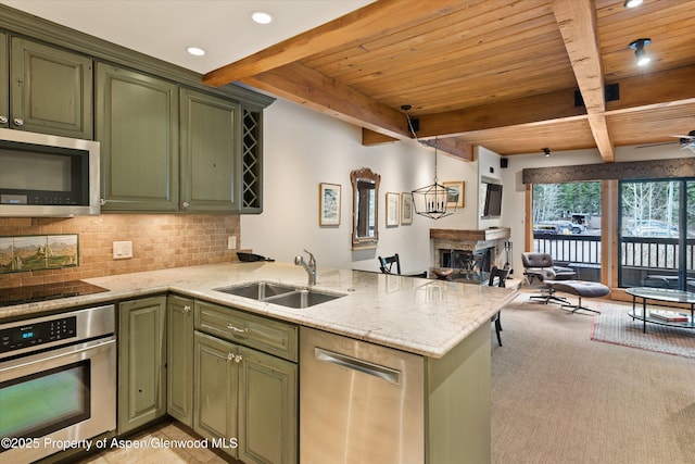 610 S W End St Unit D203, Aspen, CO 81611 - kitchen featuring green cabinets, stainless steel appliances, a sink, a fireplace, and wood ceiling with exposed beams