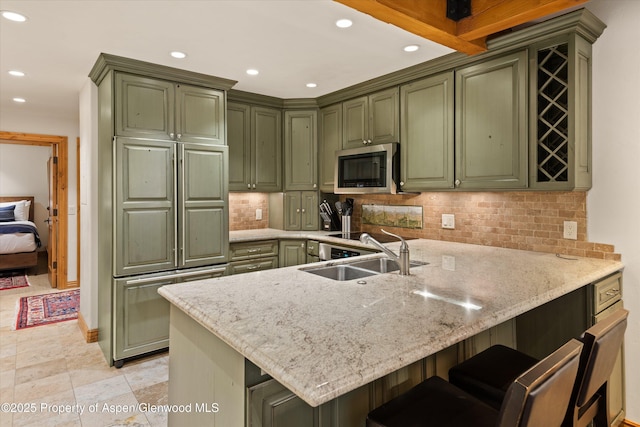 610 S W End St Unit D203, Aspen, CO 81611 - kitchen featuring green cabinetry, stainless steel microwave, a sink, a peninsula, and recessed lighting