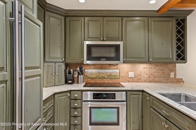 610 S W End St Unit D203, Aspen, CO 81611 - kitchen featuring stainless steel appliances, green cabinetry, decorative backsplash, light stone countertops, and recessed lighting