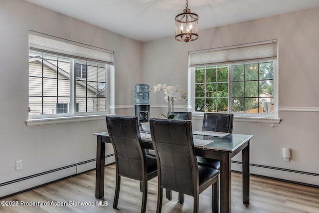dining space with a notable chandelier, wood finished floors, and a baseboard radiator
