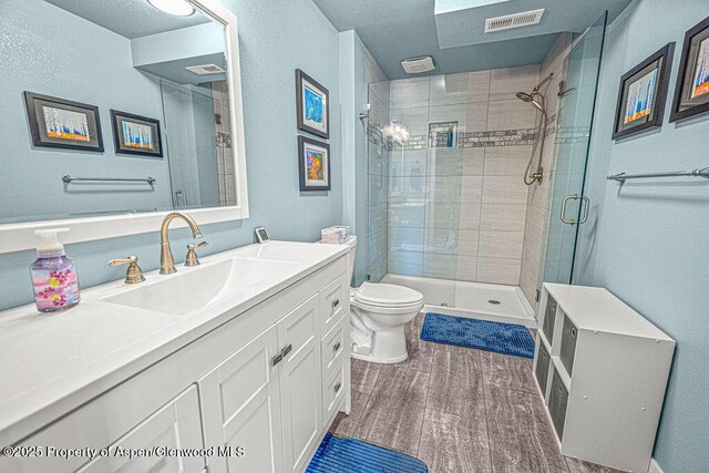 1321 Lecuyer Dr, Craig, CO 81625 - bathroom featuring toilet, vanity, a stall shower, and wood finished floors