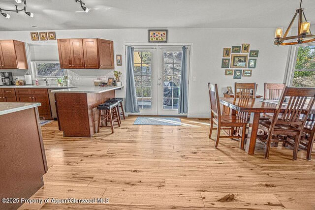 1321 Lecuyer Dr, Craig, CO 81625 - kitchen with light wood-style flooring, french doors, light countertops, a chandelier, and a kitchen breakfast bar