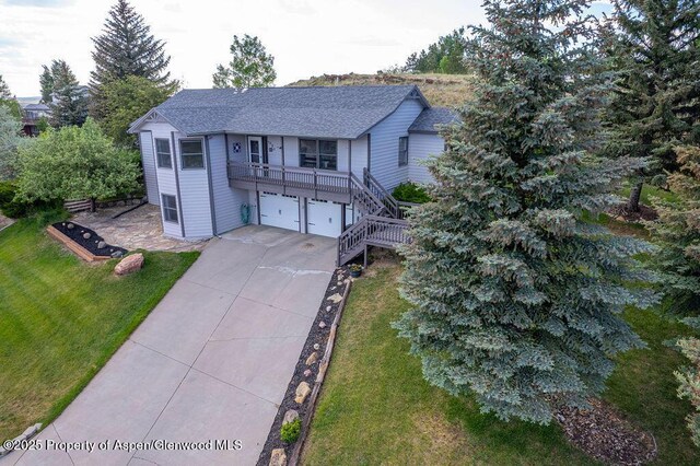 1321 Lecuyer Dr, Craig, CO 81625 - view of front of property with a front lawn, an attached garage, concrete driveway, stairs, and a shingled roof