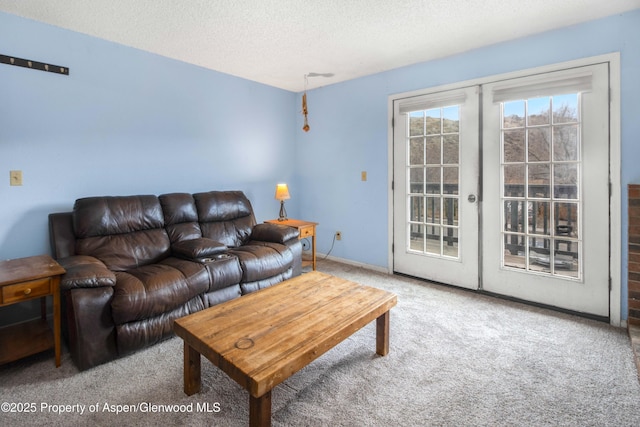 living room with carpet, a textured ceiling, and french doors