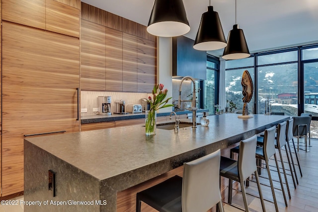 45 Wood Rd Unit 301, Snowmass Village, CO 81615 - kitchen with dark countertops, modern cabinets, a breakfast bar area, a spacious island, and expansive windows