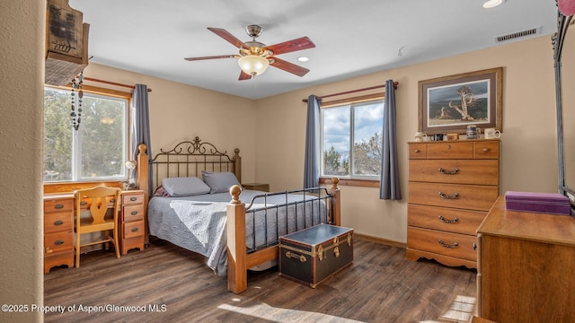 bedroom with dark hardwood / wood-style flooring and ceiling fan