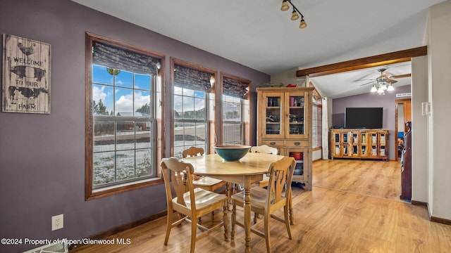 dining space featuring ceiling fan, lofted ceiling, and light wood-type flooring