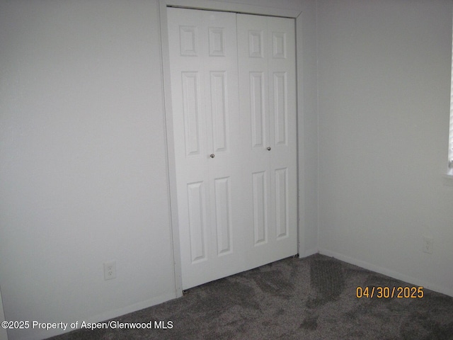 unfurnished bedroom featuring baseboards, a closet, and carpet floors