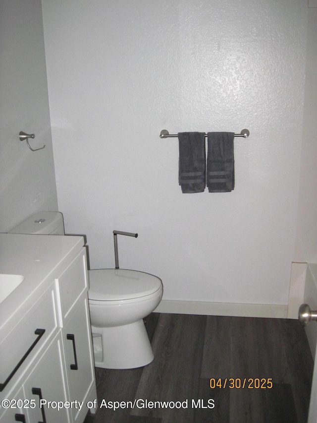 bathroom featuring toilet, wood finished floors, and vanity