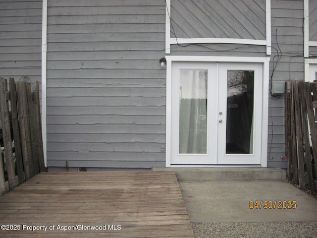 entrance to property featuring fence, french doors, and a deck