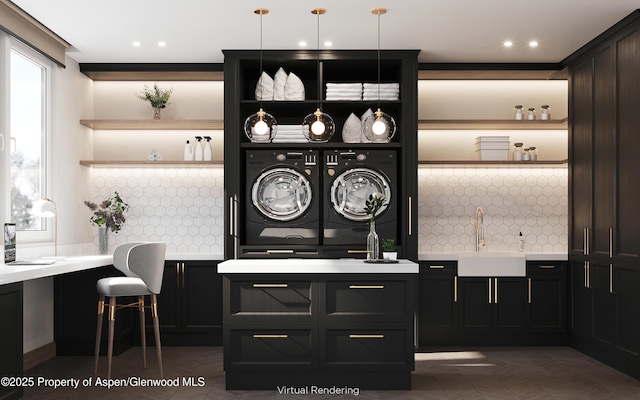 interior space with tasteful backsplash, sink, decorative light fixtures, and washing machine and clothes dryer