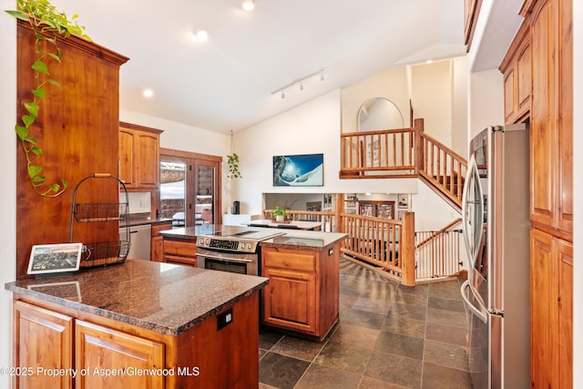 kitchen featuring appliances with stainless steel finishes, lofted ceiling, a kitchen island, and rail lighting