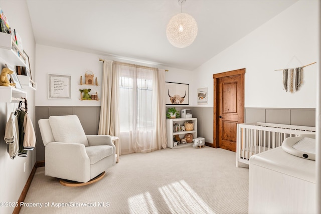 bedroom featuring vaulted ceiling, carpet floors, and a nursery area