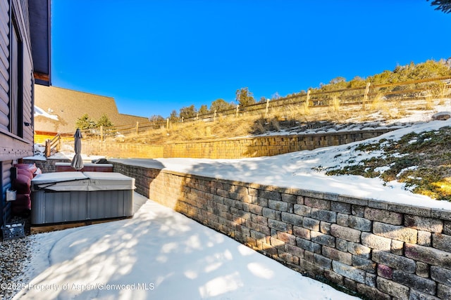 snow covered patio featuring a hot tub