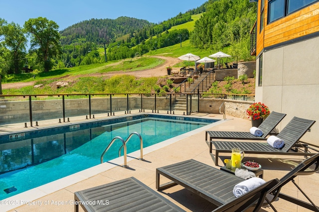 809 S Aspen St Unit 8, Aspen, CO 81611 - view of swimming pool featuring a view of trees, a patio, and stairs