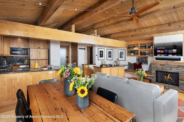 809 S Aspen St Unit 8, Aspen, CO 81611 - dining space with wooden ceiling, a ceiling fan, a stone fireplace, and wood finished floors