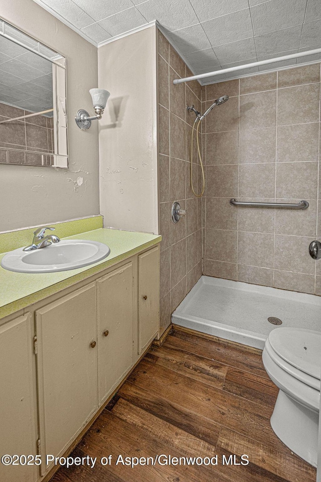 415 Tucker St, Craig, CO 81625 - bathroom featuring vanity, a tile shower, wood finished floors, and toilet