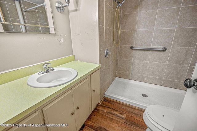 415 Tucker St, Craig, CO 81625 - bathroom with a tile shower, vanity, wood finished floors, and toilet