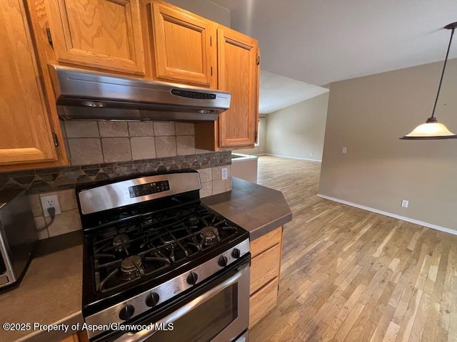 kitchen featuring stainless steel range with gas cooktop, tile countertops, pendant lighting, backsplash, and light wood-type flooring