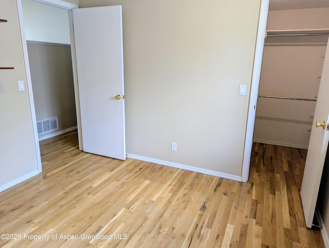 unfurnished bedroom featuring light hardwood / wood-style flooring and a closet