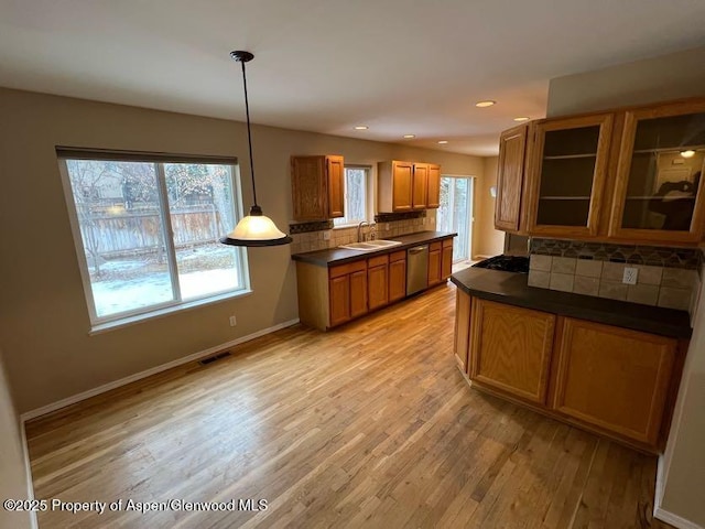 kitchen with pendant lighting, sink, light hardwood / wood-style flooring, dishwasher, and decorative backsplash