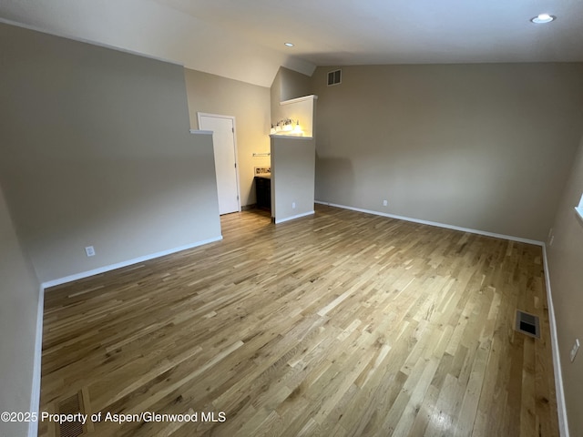 empty room featuring lofted ceiling and hardwood / wood-style floors