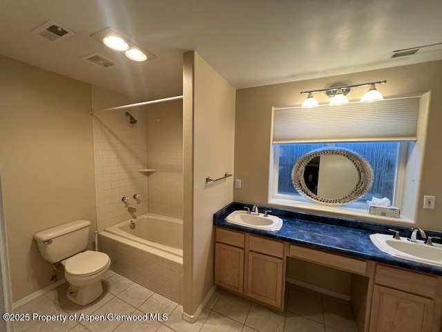 full bathroom featuring tile patterned floors, vanity, toilet, and tiled shower / bath combo