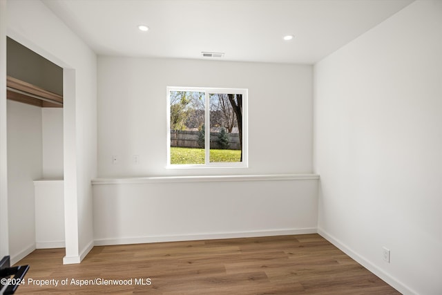 unfurnished bedroom featuring wood-type flooring and a closet