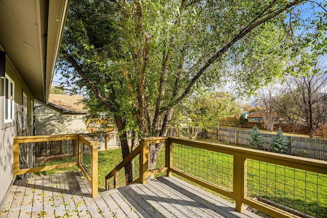 wooden terrace featuring a yard