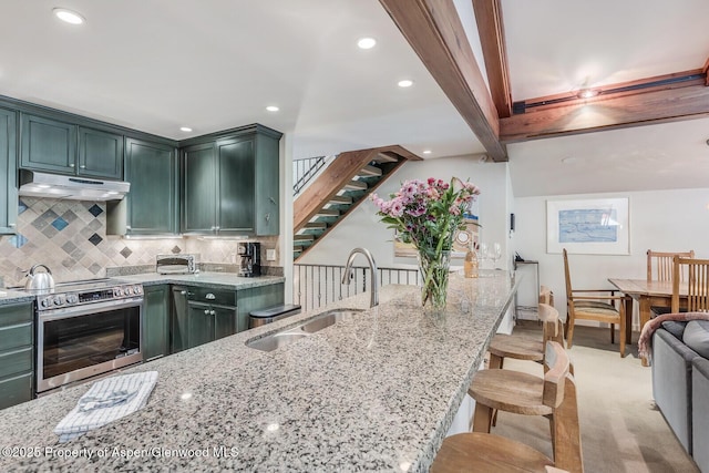 851 Ute Ave Unit B, Aspen, CO 81611 - kitchen with electric stove, under cabinet range hood, light stone counters, green cabinetry, and backsplash