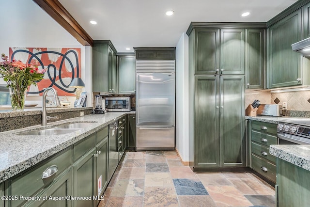 851 Ute Ave Unit B, Aspen, CO 81611 - kitchen with green cabinets, appliances with stainless steel finishes, light stone counters, stone tile flooring, and recessed lighting