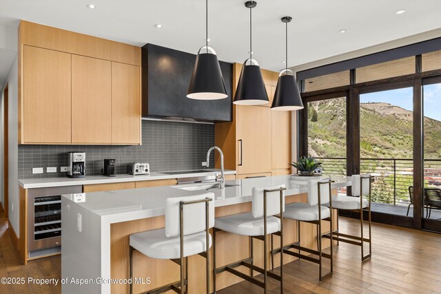 77 Wood Rd Unit 507-13, Snowmass Village, CO 81615 - kitchen with wine cooler, an island with sink, tasteful backsplash, light countertops, and recessed lighting