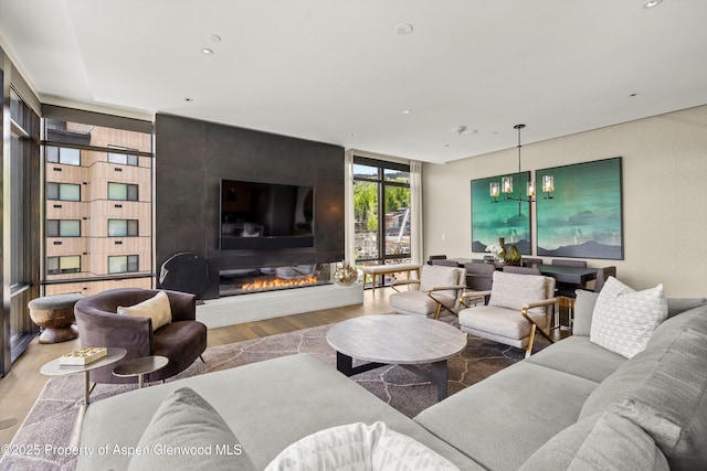 77 Wood Rd Unit 507-13, Snowmass Village, CO 81615 - living room with wood finished floors, a fireplace, recessed lighting, a chandelier, and a wall of windows