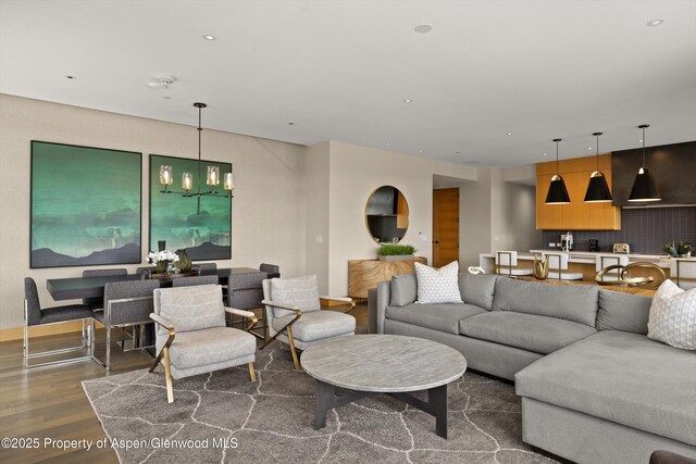 77 Wood Rd Unit 507-13, Snowmass Village, CO 81615 - living room with wood finished floors, a chandelier, and baseboards